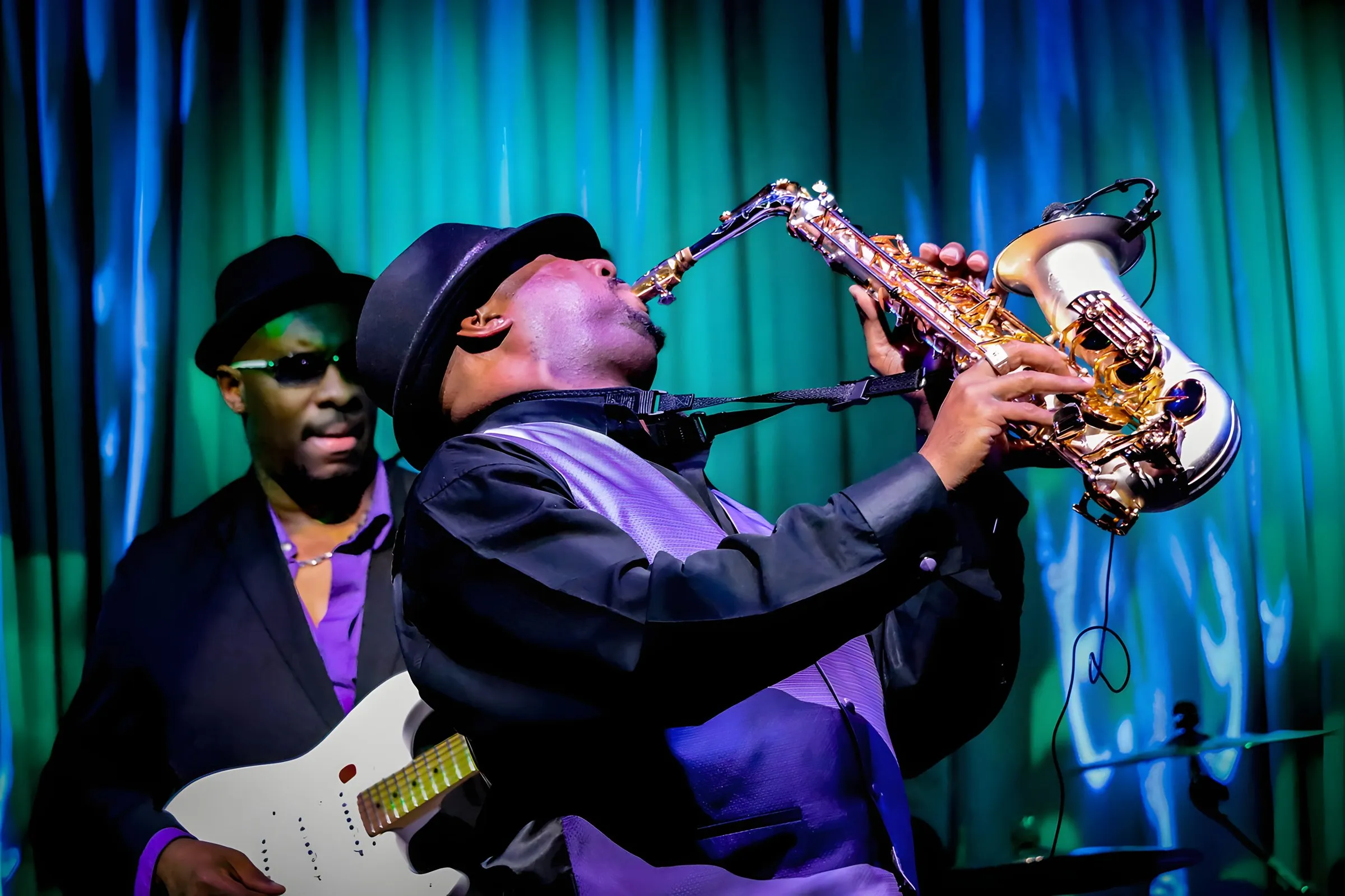 A saxophonist and guitarist playing live