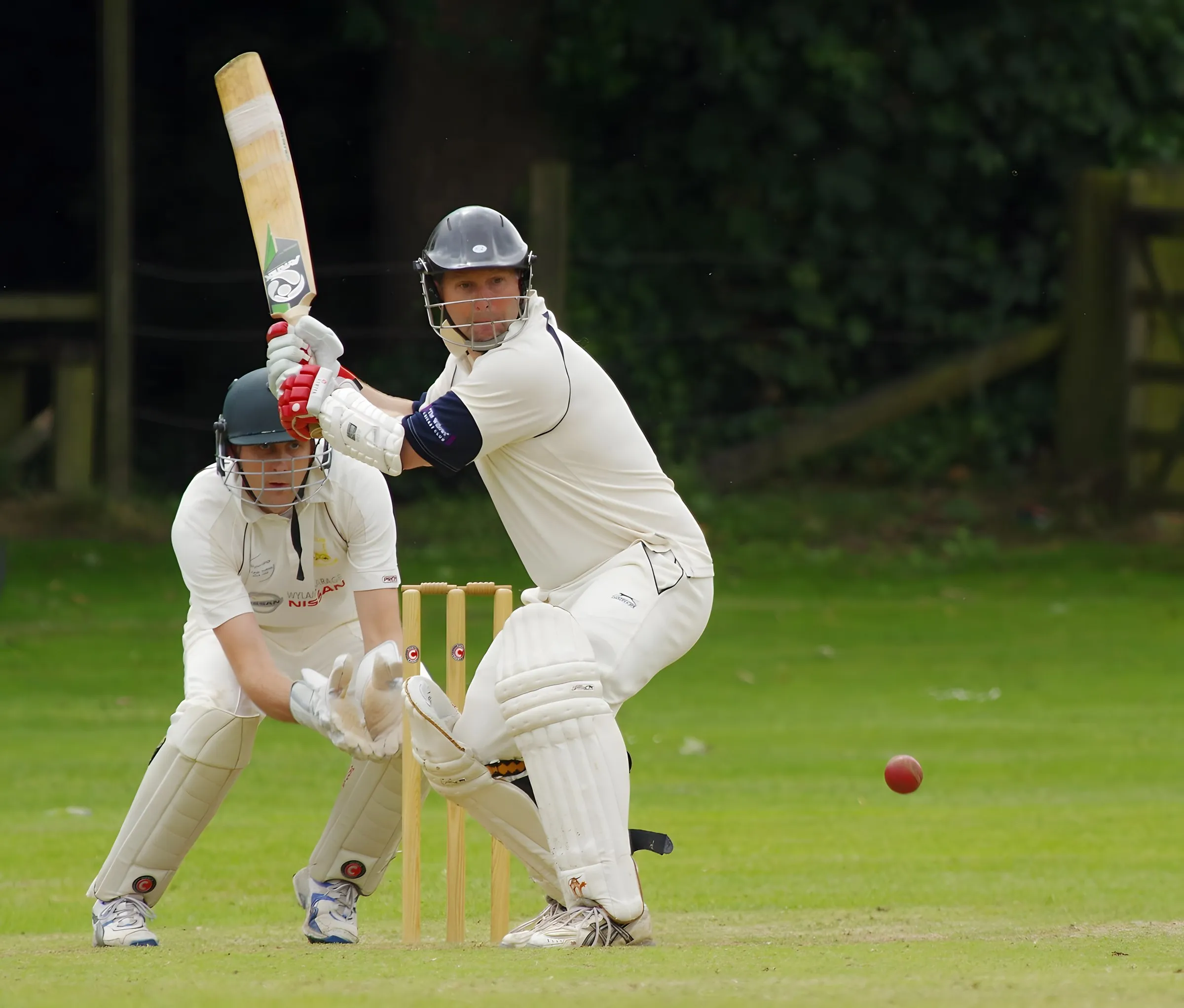 A batsman and wicketkeeper in a club cricket match