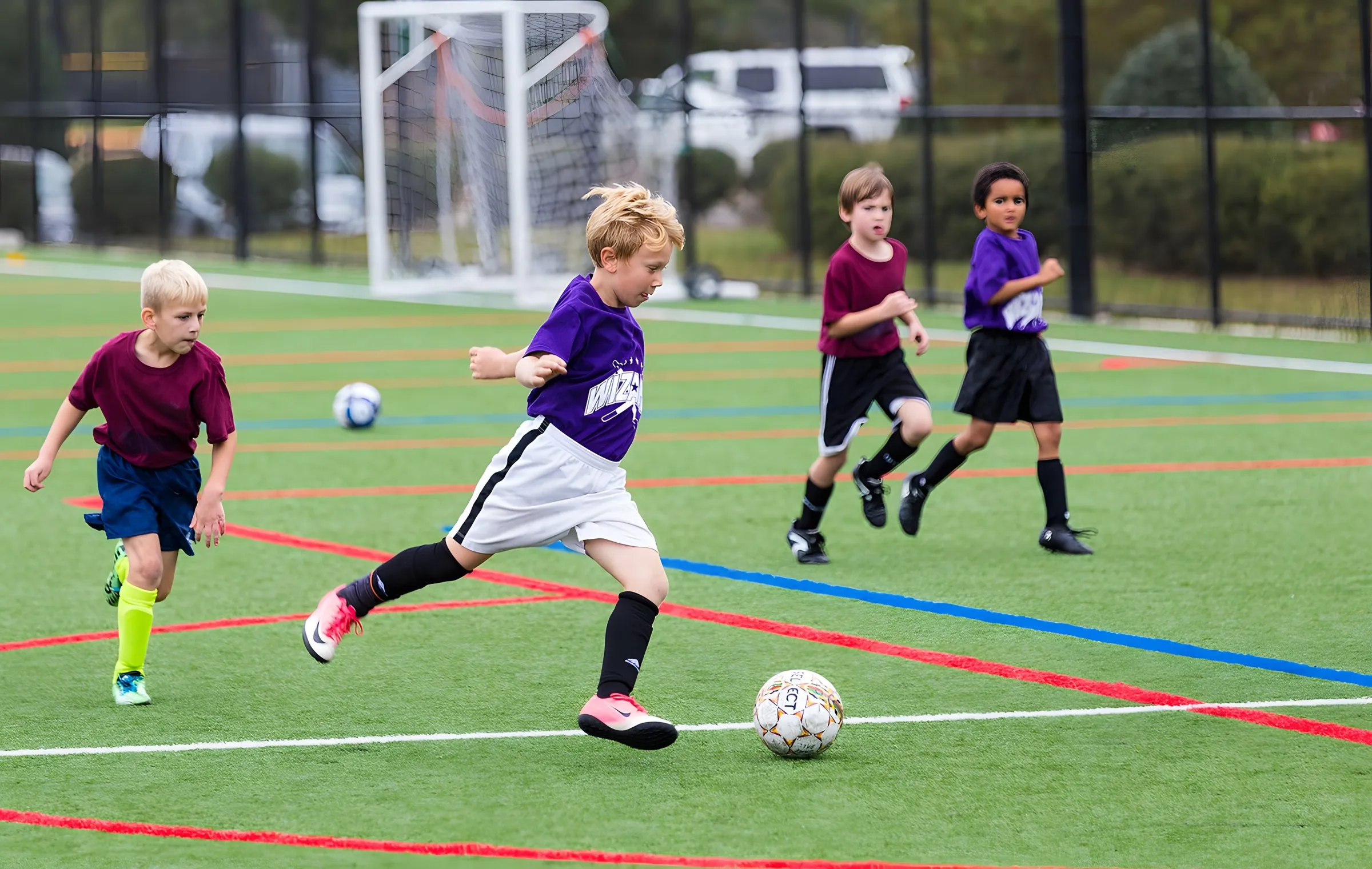 Children playing football on an all-weather pitch
